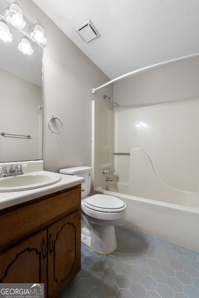 bathroom featuring tile patterned flooring, vanity, toilet, and shower / tub combination