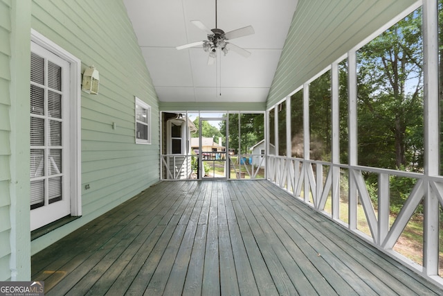 unfurnished sunroom with ceiling fan and vaulted ceiling