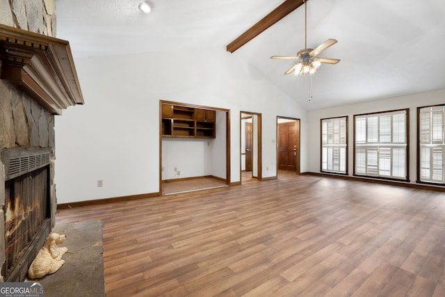 unfurnished living room featuring a fireplace, a ceiling fan, beamed ceiling, baseboards, and light wood-style flooring