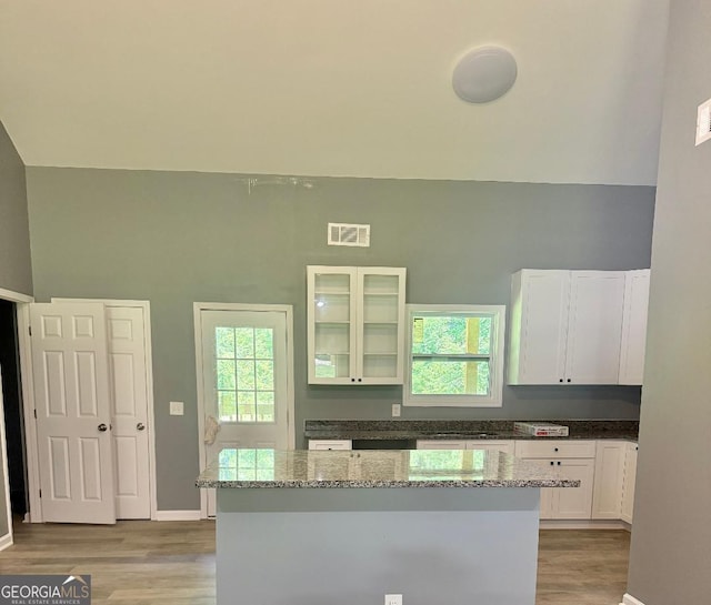 191 Deerfield Ln, Carrollton, GA 30116 - kitchen featuring light wood-style flooring, white cabinetry, light stone countertops, and a center island