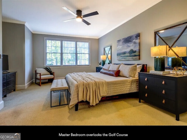 carpeted bedroom with crown molding, baseboards, and a ceiling fan