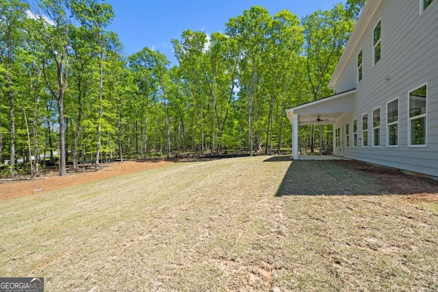 view of grassy yard with a ceiling fan