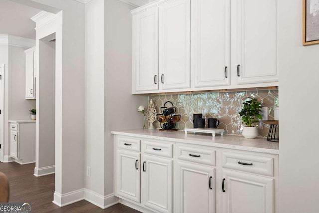 bar area with tasteful backsplash, dark wood-style flooring, and baseboards