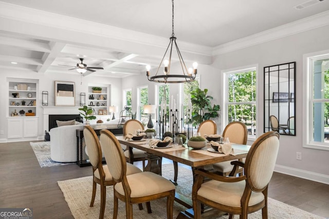 dining space with plenty of natural light, dark wood-style flooring, built in shelves, baseboards, and beam ceiling