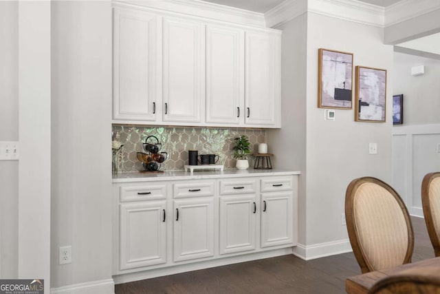 bar with decorative backsplash, dark wood-style flooring, crown molding, and baseboards