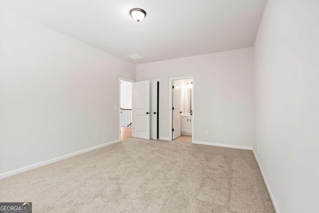 2749 Porches Ln, Dacula, GA 30019 - unfurnished bedroom featuring light colored carpet, baseboards, and ensuite bathroom