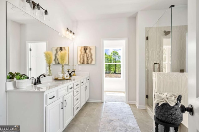 bathroom with a stall shower, double vanity, and tile patterned floors