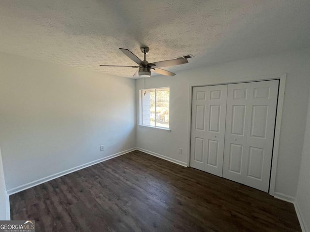 3417 Hollow Tree Dr, Decatur, GA 30034 - unfurnished bedroom with dark wood-type flooring, a textured ceiling, baseboards, a closet, and a ceiling fan