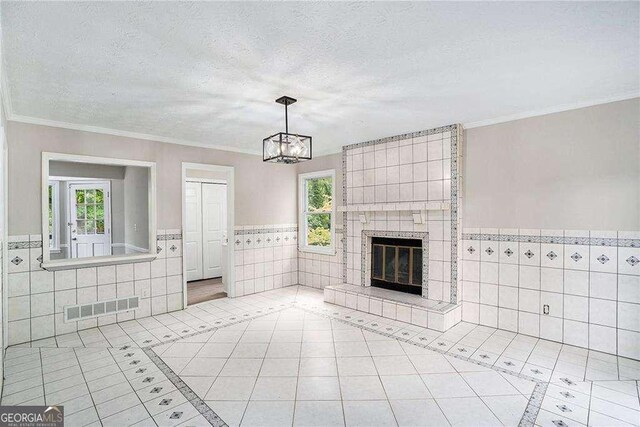 3333 Devaughn Dr NE, Marietta, GA 30066 - unfurnished living room with tile walls, light tile patterned flooring, a wainscoted wall, a chandelier, and a textured ceiling