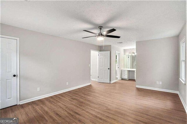 3333 Devaughn Dr NE, Marietta, GA 30066 - unfurnished bedroom with wood finished floors, baseboards, a textured ceiling, ensuite bath, and ceiling fan