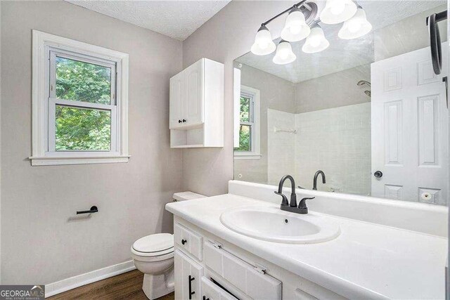 3333 Devaughn Dr NE, Marietta, GA 30066 - bathroom with a tile shower, wood finished floors, baseboards, toilet, and vanity