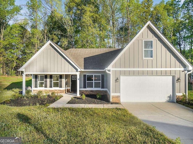 733 Springhill Dr, Gray, GA 31032 - view of front of house featuring board and batten siding, a front yard, driveway, and stone siding