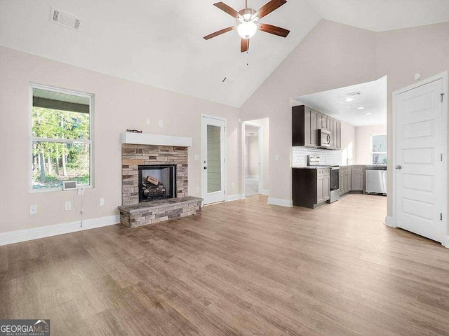 733 Springhill Dr, Gray, GA 31032 - unfurnished living room featuring ceiling fan, high vaulted ceiling, light wood finished floors, baseboards, and a fireplace