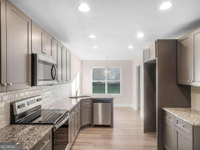 733 Springhill Dr, Gray, GA 31032 - kitchen with appliances with stainless steel finishes, a sink, light wood-style flooring, light stone counters, and tasteful backsplash
