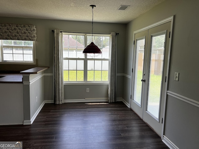 120 Magnolia Trl, Milner, GA 30257 - unfurnished dining area with dark wood-type flooring, healthy amount of natural light, a textured ceiling, and baseboards