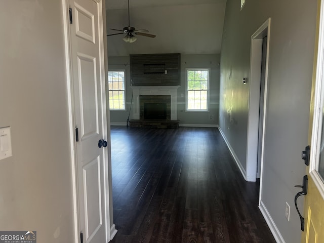 120 Magnolia Trl, Milner, GA 30257 - unfurnished living room with dark wood-type flooring, baseboards, ceiling fan, vaulted ceiling, and a fireplace