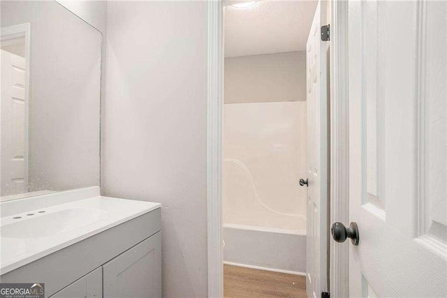 4902 Cedar Ct SE, Conyers, GA 30094 - full bathroom with vanity, wood finished floors, and shower / bath combination
