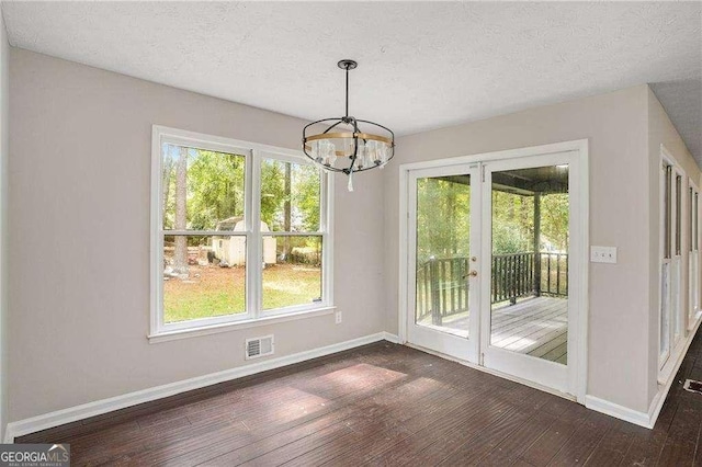 4902 Cedar Ct SE, Conyers, GA 30094 - unfurnished dining area with baseboards, dark wood-style flooring, a chandelier, a textured ceiling, and plenty of natural light