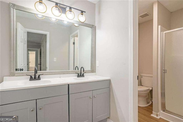 4902 Cedar Ct SE, Conyers, GA 30094 - full bathroom featuring toilet, a shower stall, double vanity, and wood finished floors
