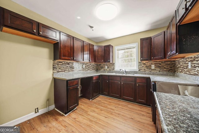 2703 Flagstone Dr SE, Atlanta, GA 30316 - kitchen with light wood-style flooring, backsplash, dark brown cabinets, and stone countertops