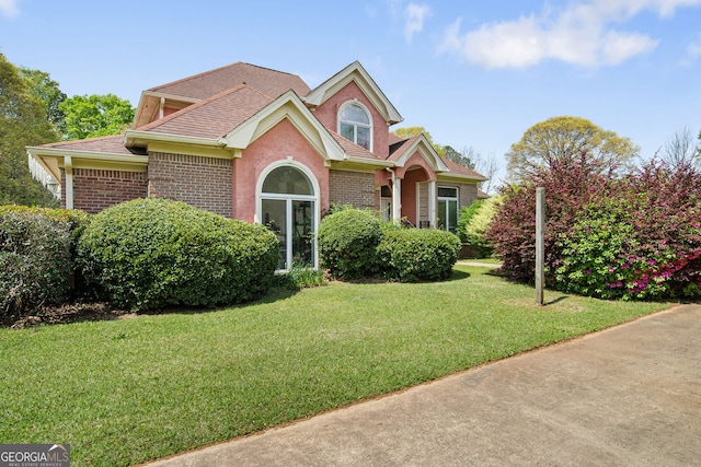 104 Bob White Run, Jackson, GA 30233 - traditional-style house featuring brick siding, a front yard, and roof with shingles