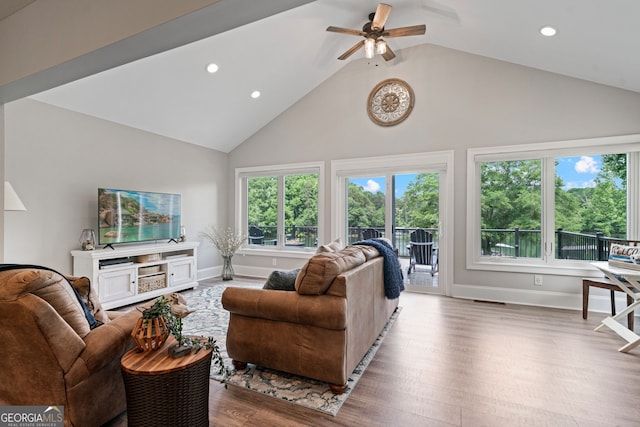 living room with high vaulted ceiling, plenty of natural light, ceiling fan, recessed lighting, and wood finished floors