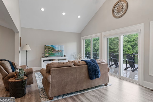 living room with high vaulted ceiling, wood finished floors, recessed lighting, and baseboards