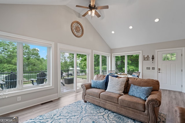 living area with high vaulted ceiling, a ceiling fan, plenty of natural light, recessed lighting, and wood finished floors
