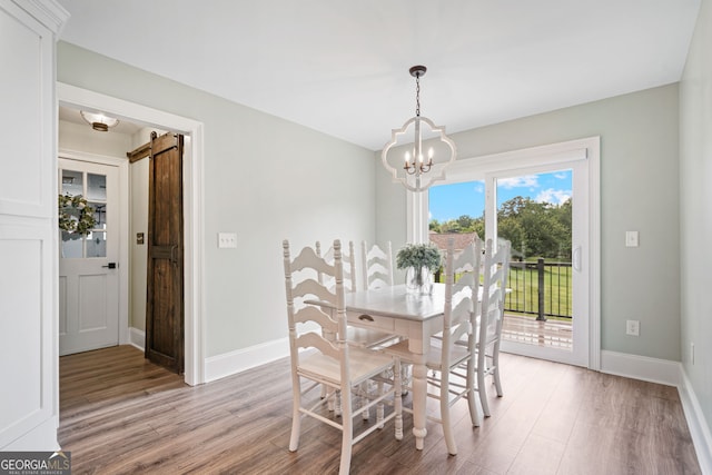 dining area with a chandelier, light wood-style floors, and baseboards