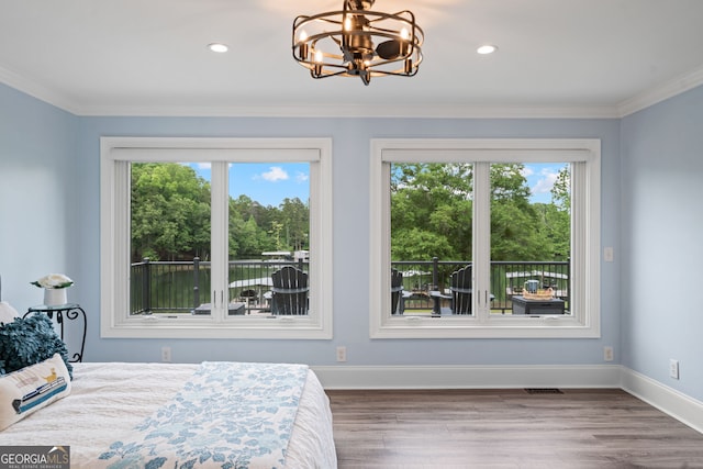 bedroom featuring multiple windows, wood finished floors, a chandelier, baseboards, and crown molding