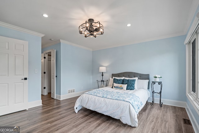 bedroom featuring wood finished floors, a chandelier, baseboards, ornamental molding, and recessed lighting