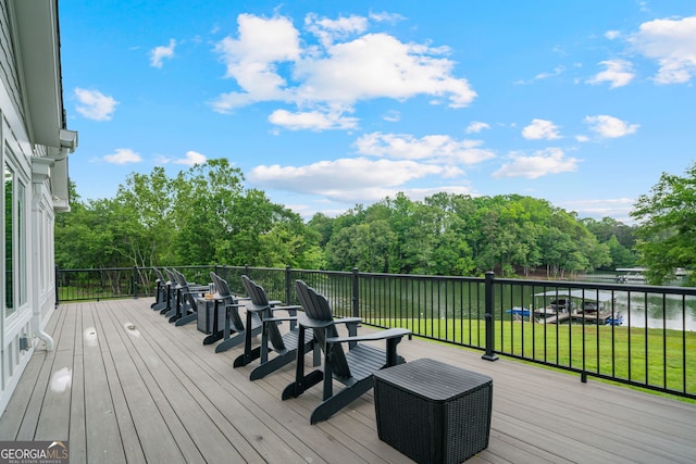 deck with a lawn and a water view