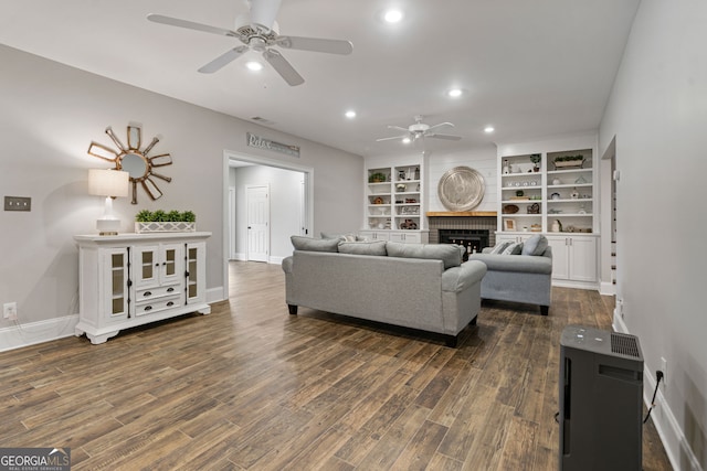 living area with a ceiling fan, dark wood-style flooring, recessed lighting, baseboards, and a fireplace
