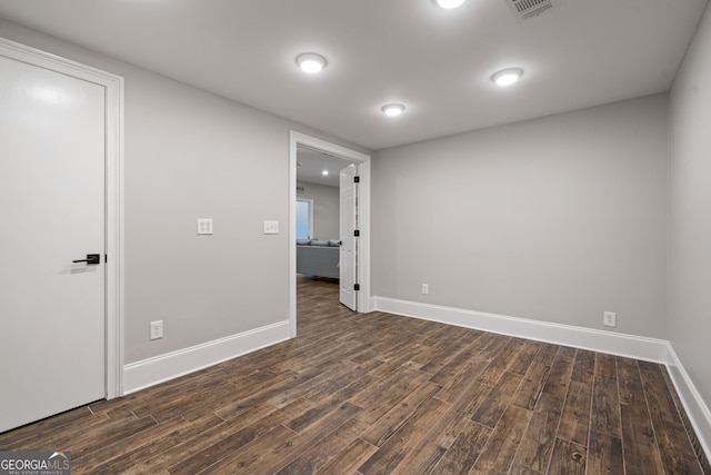 empty room featuring dark wood finished floors and baseboards