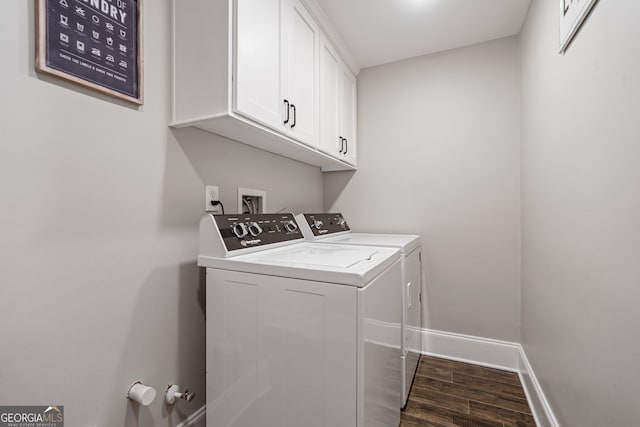 laundry room featuring washing machine and dryer, wood finished floors, baseboards, and cabinet space