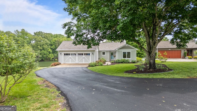 view of front of house featuring driveway, a front lawn, and a garage
