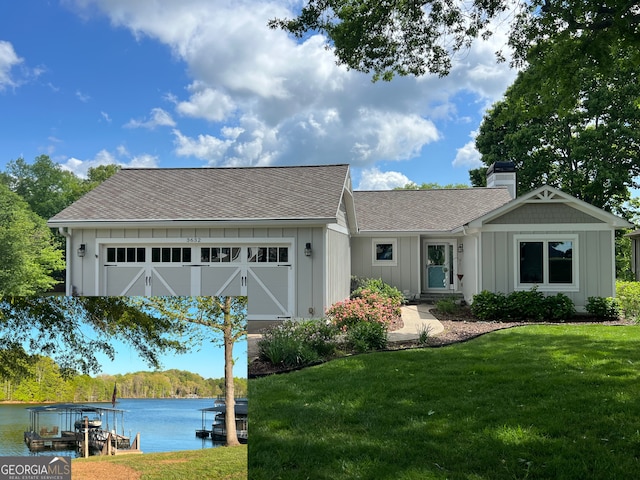 view of front of house featuring board and batten siding, a chimney, roof with shingles, a front yard, and a water view