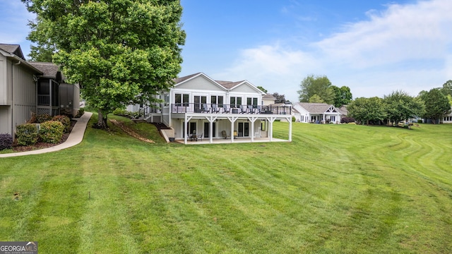 back of property with a patio, a wooden deck, and a lawn