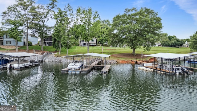 dock with boat lift, a water view, and a yard