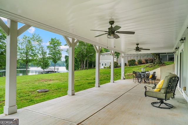 view of patio with a water view and a ceiling fan