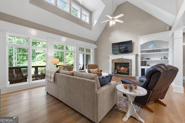 130 Allie Dr, Mcdonough, GA 30252 - living room with high vaulted ceiling, a brick fireplace, a ceiling fan, and light wood finished floors