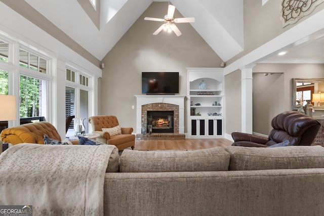 130 Allie Dr, Mcdonough, GA 30252 - living area featuring high vaulted ceiling, wood finished floors, a fireplace, decorative columns, and a ceiling fan