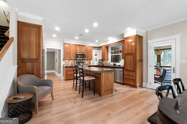 130 Allie Dr, Mcdonough, GA 30252 - kitchen with stainless steel appliances, a kitchen breakfast bar, a center island, brown cabinets, and tasteful backsplash