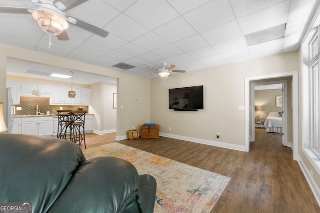 130 Allie Dr, Mcdonough, GA 30252 - living room with ceiling fan, wood finished floors, baseboards, and a paneled ceiling