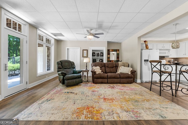 130 Allie Dr, Mcdonough, GA 30252 - living room featuring baseboards, wood finished floors, ceiling fan, and a paneled ceiling