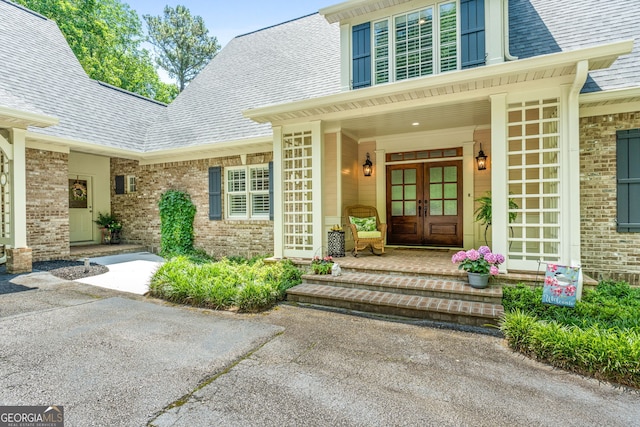 130 Allie Dr, Mcdonough, GA 30252 - entrance to property featuring french doors, roof with shingles, brick siding, and a porch