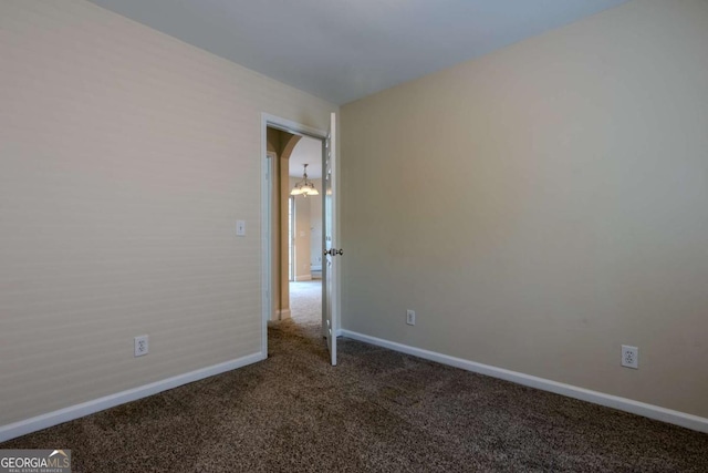 spare room featuring carpet flooring and baseboards