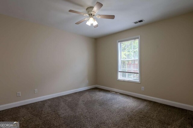 empty room featuring carpet, baseboards, and a ceiling fan