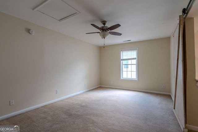 carpeted spare room featuring baseboards, ceiling fan, and a smoke detector