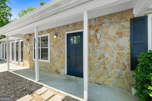 1404 Meadowind Ct SW, Conyers, GA 30094 - doorway to property featuring stone siding and a porch